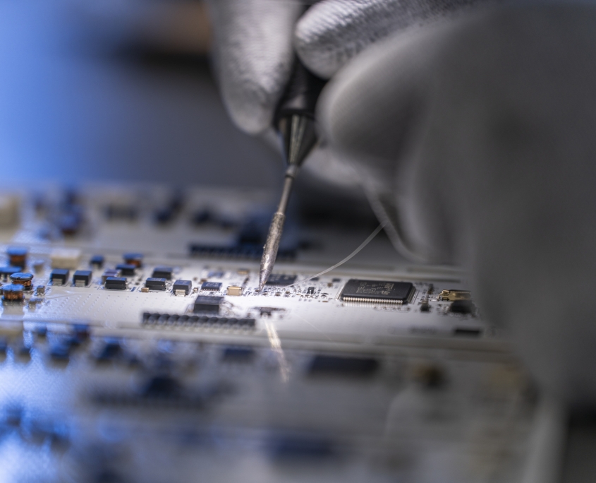 Produzione elettronica reparto SMD, particolare di modifica manuale di un circuito elettronico